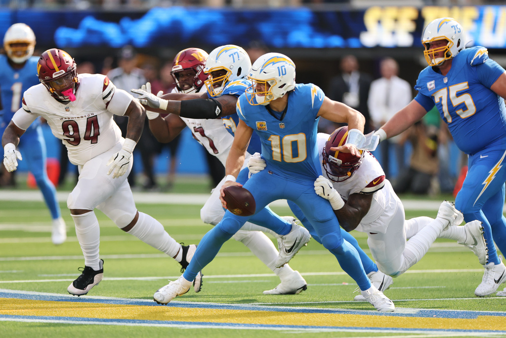 Los Angeles Chargers quarterback Justin Herbert (10) is sacked by Washington Commanders defensive end Dorance Armstrong during the second half of an NFL football game Sunday, Oct. 5, 2025, in Inglewood, Calif. (AP Photo/Eric Thayer)