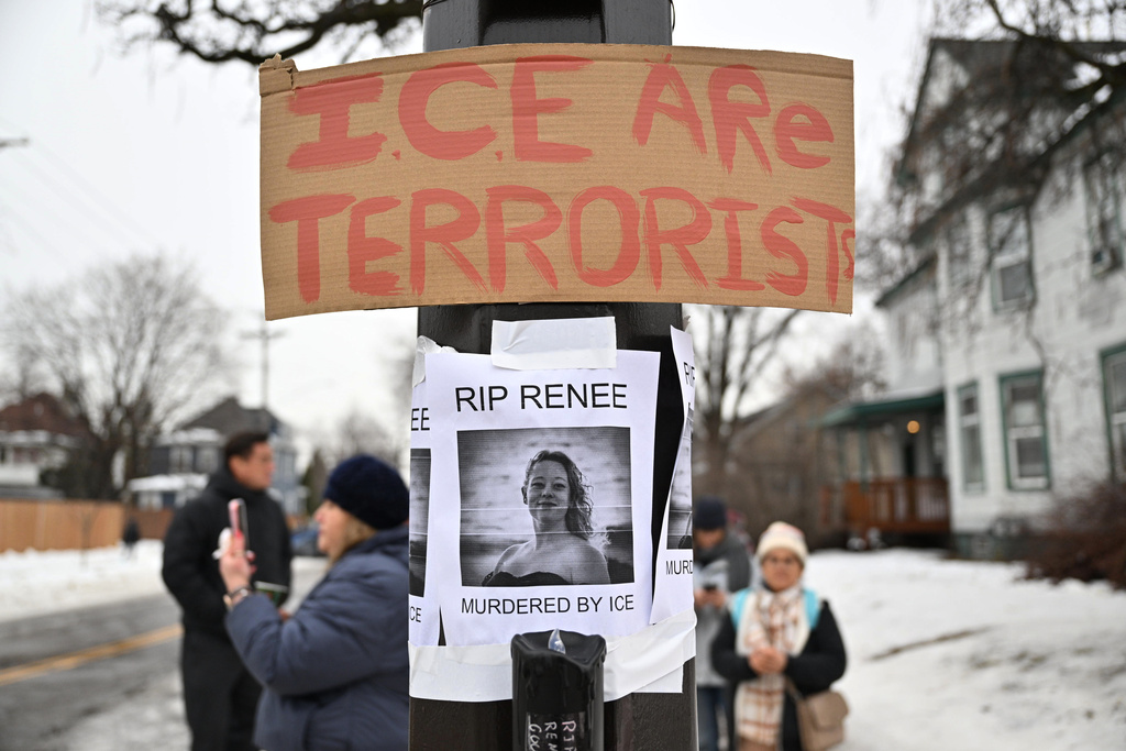 People gather around a makeshift memorial honoring the victim of a fatal shooting involving federal law enforcement agents, near the site of the shooting, Thursday, Jan. 8, 2026, in Minneapolis. (AP Photo/Tom Baker)