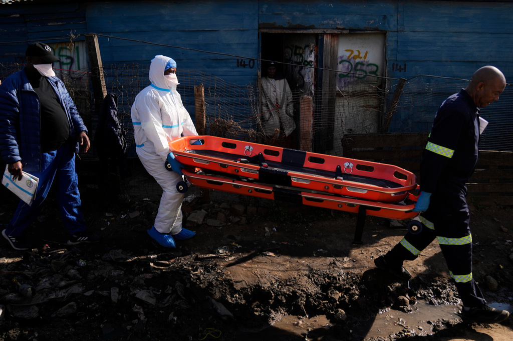 Police officers carry stretchers after a mass shooting at an informal settlement in the Cleveland suburb of Johannesburg, South Africa, Wednesday, June 10, 2026. (AP Photo/Themba Hadebe)