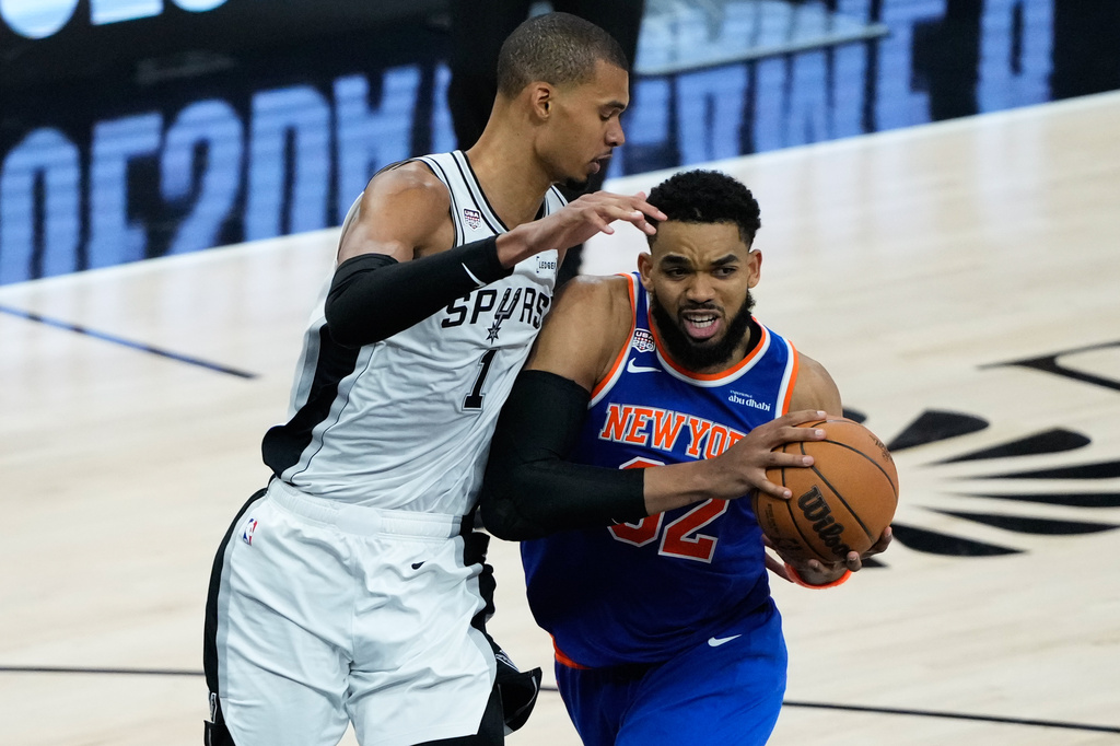 New York Knicks center Karl-Anthony Towns (32) drives as San Antonio Spurs forward Victor Wembanyama defends during the second half of Game 5 of the NBA Finals basketball series, Saturday, June 13, 2026, in San Antonio. (AP Photo/Ross D. Franklin)