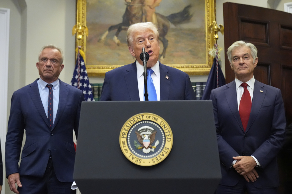 President Donald Trump speaks in the Roosevelt Room of the White House, Monday, Sept. 22, 2025, in Washington, as Health and Human Services Secretary Robert F. Kennedy Jr., left, and Centers for Medicare & Medicaid Services administrator Dr. Mehmet Oz listen. (AP Photo/Mark Schiefelbein)