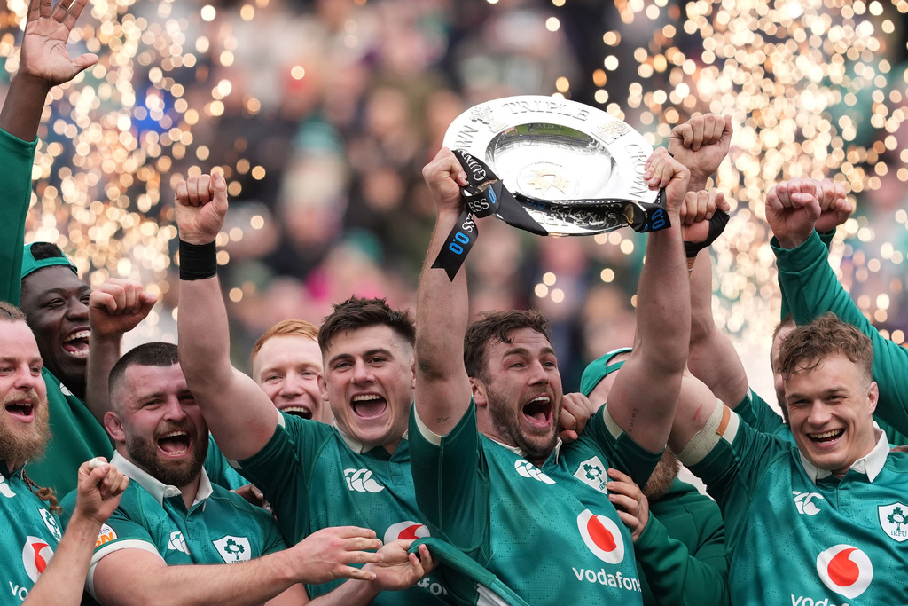 Ireland's Caelan Doris, center, lifts the Triple Crown trophy with teammates after the Six Nations rugby union match between Ireland and Scotland, in Dublin, Saturday, March 14, 2026. (Brian Lawless/PA via AP)