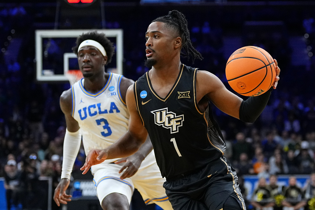 UCF's Themus Fulks, right, gets past UCLA's Eric Dailey Jr. during the first half in the first round of the NCAA college basketball tournament, Friday, March 20, 2026, in Philadelphia. (AP Photo/Matt Rourke)