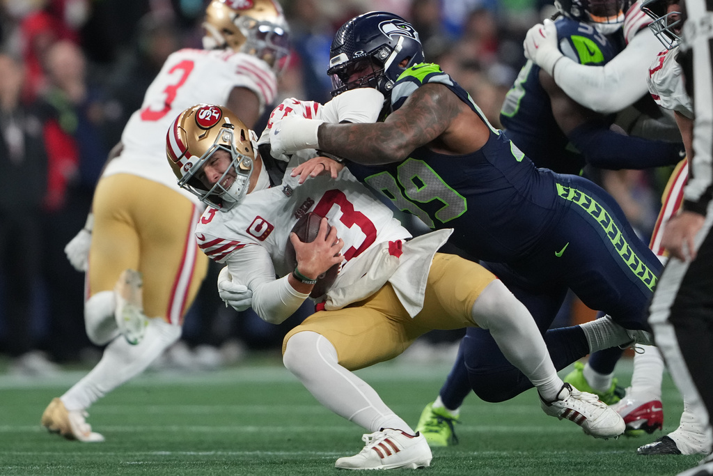 Seattle Seahawks defensive tackle Leonard Williams (99) sacks San Francisco 49ers quarterback Brock Purdy (13) during the second half of an NFL football divisional playoff game Saturday, Jan. 17, 2026, in Seattle. (AP Photo/Lindsey Wasson)