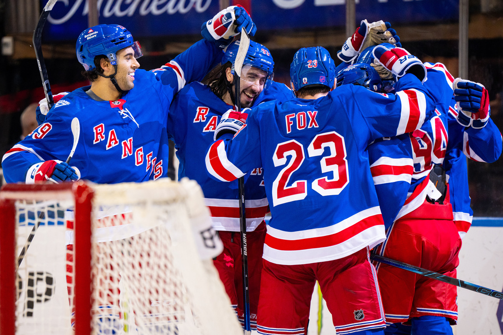 New York Rangers players celebrate a third goal against the Calgary Flames during the second period of an NHL hockey game, Tuesday, March 10, 2026, in New York. (AP Photo/Angelina Katsanis)