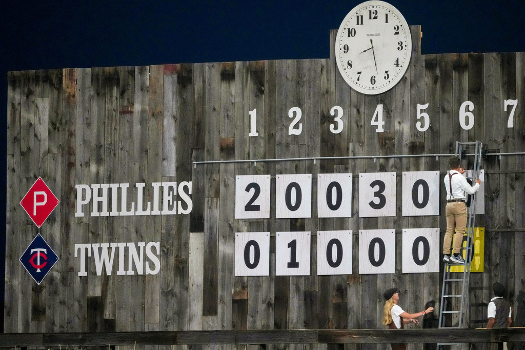 Scoreboard workers change an inning number during a baseball game between the Minnesota Twins and the Philadelphia Phillies at the Field of Dreams movie site, Thursday, Aug. 13, 2026, in Dyersville, Iowa. (AP Photo/Charlie Neibergall)
