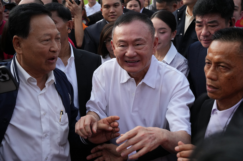 Former Thailand Prime Minister Thaksin Shinawatra, center, walks among his supporters following his release on parole from a Bangkok prison in Bangkok, Thailand, Monday, May 11, 2026. (AP Photo/Sakchai Lalit)