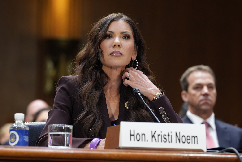 Homeland Security Secretary Kristi Noem, center, with her husband Bryon Noem, right, seated behind her, appears for an oversight hearing before the Senate Judiciary Committee, at the Capitol in Washington, Tuesday, March 3, 2026. (AP Photo/J. Scott Applewhite)