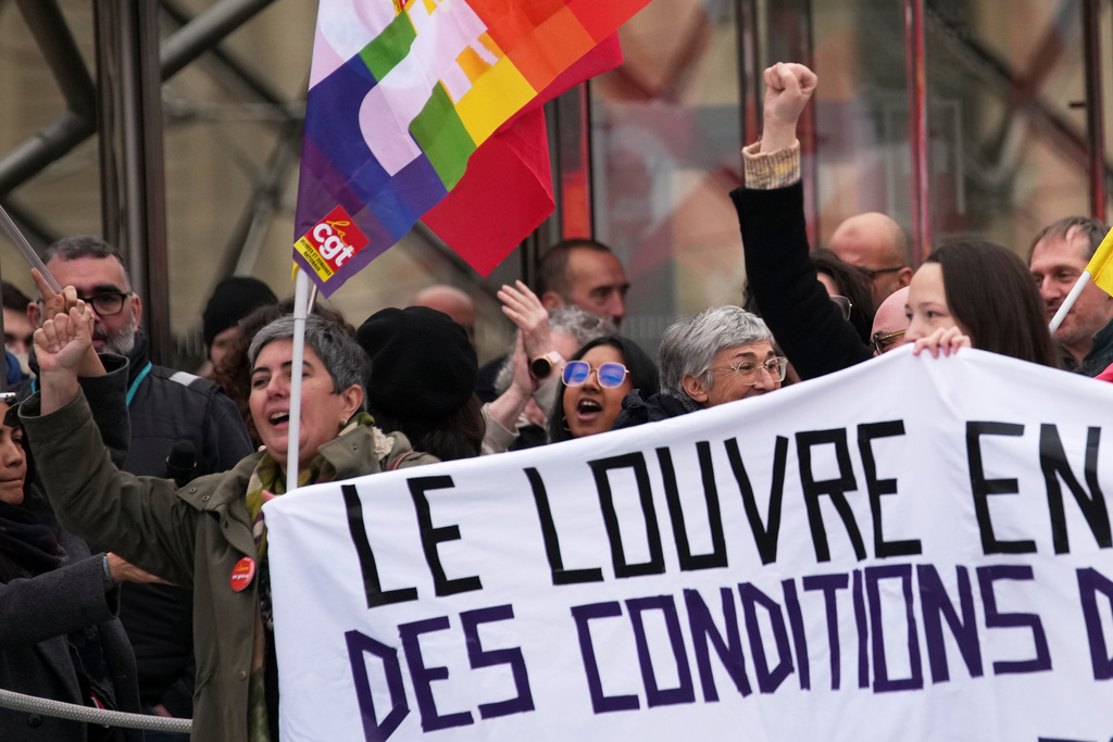 Unionists display a banner and union flags outside the Louvre museum after employees have voted to extend a strike that has disrupted operations at the world's most visited museum, Wednesday, Dec. 17, 2025 in Paris. (AP Photo/Christophe Ena)