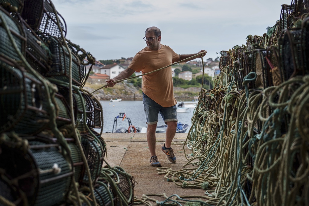 Fisherman Primitivo Pedrosa prepares octopus traps for the start of octopus fishing season after an unusually long pause period Tuesday, June 24, 2025, in Lira, Spain. (AP Photo/Annika Hammerschlag)