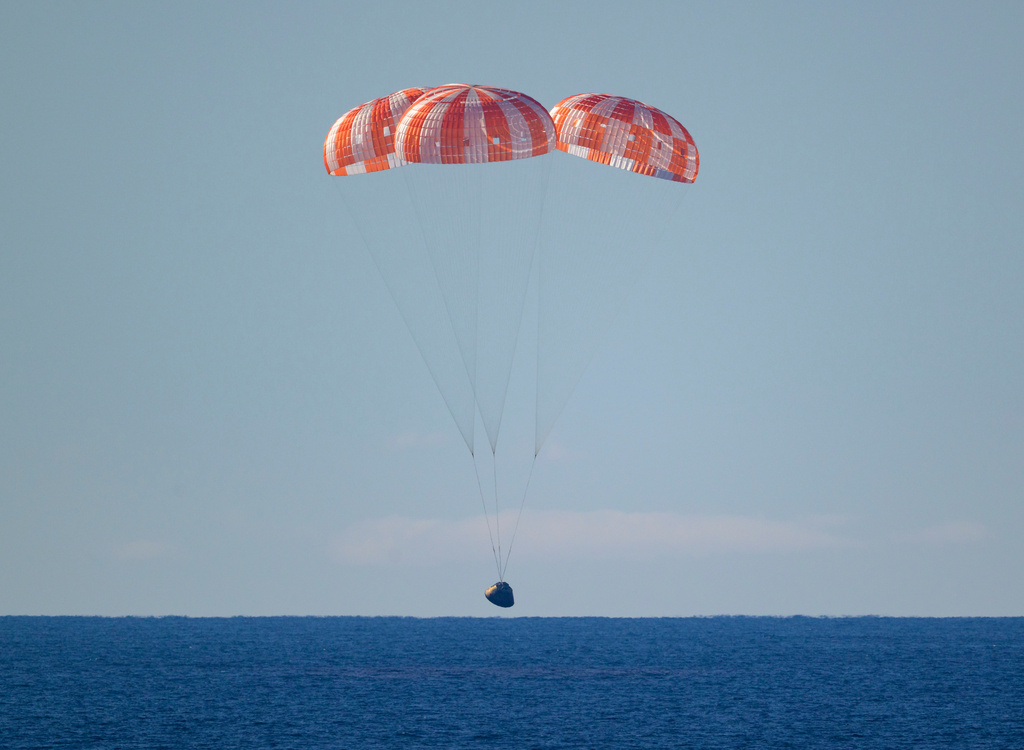 In this photo provided by NASA, the Orion spacecraft with Artemis II crewmembers aboard approaches the surface of the Pacific Ocean for splashdown off the coast of California, Friday, April 10, 2026. (Bill Ingalls/NASA via AP)