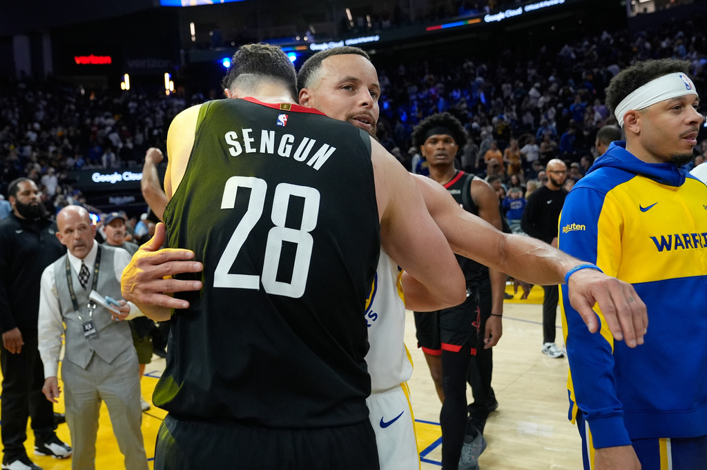 Houston Rockets center Alperen Sengun (28) is hugged by Golden State Warriors guard Stephen Curry (30) after an NBA basketball game, Sunday, April 5, 2026, in San Francisco. (AP Photo/Godofredo A. Vásquez)