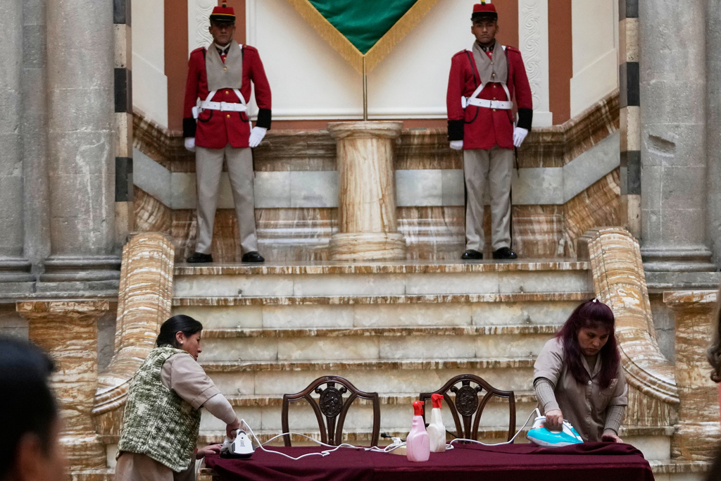 FILE - Workers at the presidential palace iron a tablecloth before the start of a press conference by Bolivian President Rodrigo Paz and Ilan Goldfajn, the president of the Inter-American Development Bank, in La Paz, Bolivia, Jan. 13, 2026. (AP Photo/Juan Karita, File)