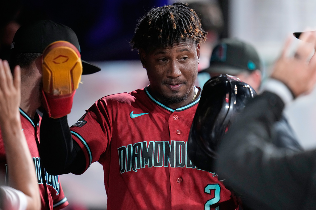 Arizona Diamondbacks' Geraldo Perdomo (2) is congratulated in the dugout after scoring in the eighth inning of a baseball game against the Cleveland Guardians in Cleveland, Friday, July 31, 2026. (AP Photo/Sue Ogrocki)