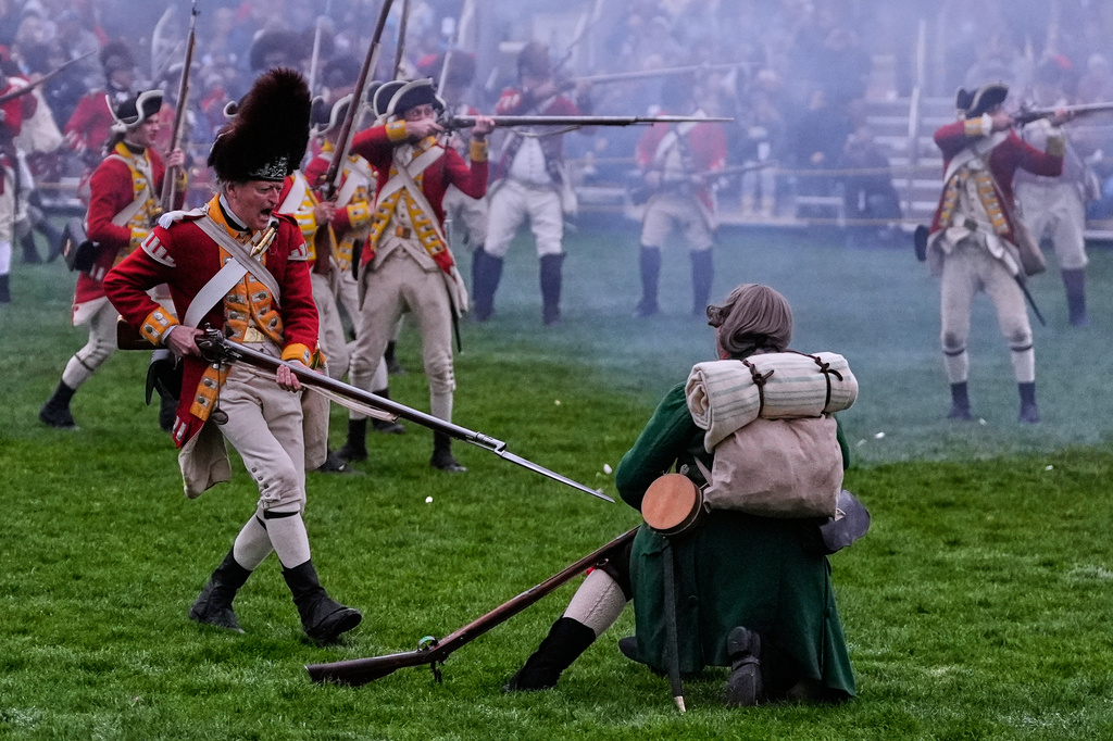 A British red coat soldier, at left, stabs a colonial minute man with a bayonet during a historic re-enactment of the Battle of Lexington, Saturday, April 18, 2026, in Lexington, Mass. (AP Photo/Charles Krupa)