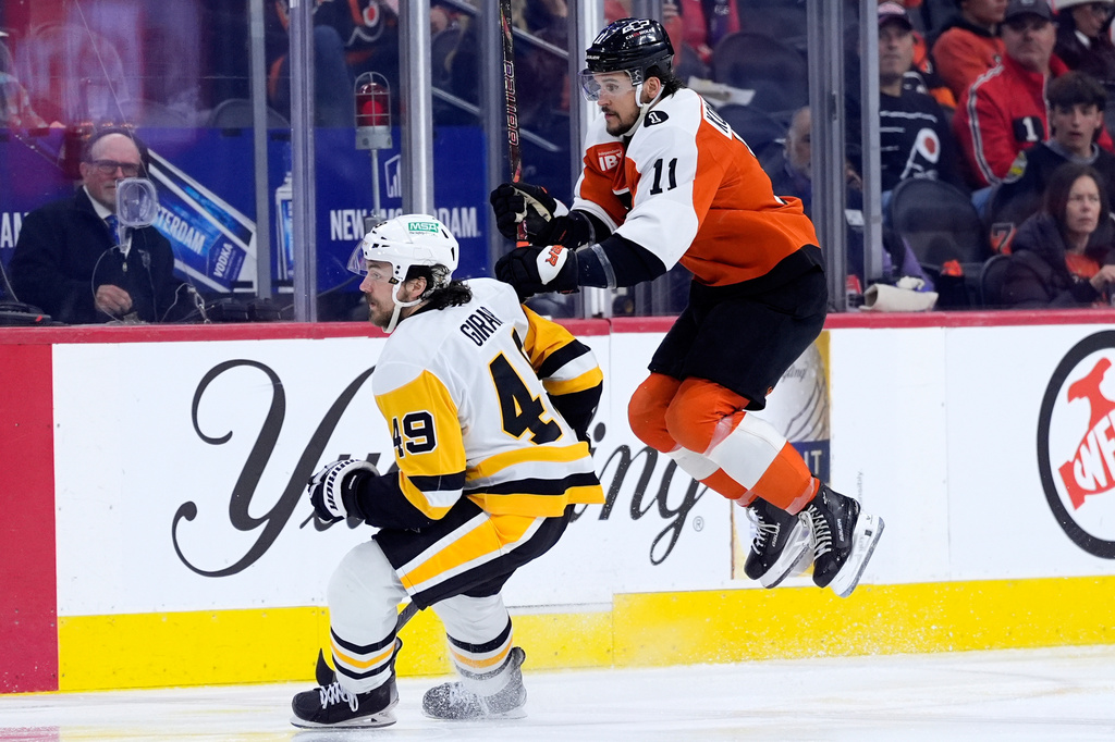 Philadelphia Flyers' Travis Konecny, right, leaps past Pittsburgh Penguins' Samuel Girard during the second period of Game 6 in the first round of the NHL hockey Stanley Cup playoffs series Wednesday, April 29, 2026, in Philadelphia. (AP Photo/Matt Slocum)