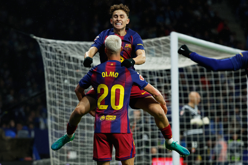 Barcelona's Dani Olmo (20) is congratulated by Fermin Lopez after scoring his side's opening goal during the Spanish La Liga soccer match between RCD Espanyol and Barcelona in Barcelona, Spain, Saturday, Jan. 3, 2026. (AP Photo/Joan Monfort)