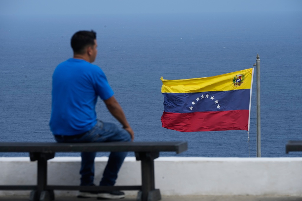 A man looks out at the sea in the city of La Guaira, Venezuela, where the nation's flag flies, Wednesday, Dec. 17, 2025. (AP Photo/Ariana Cubillos)