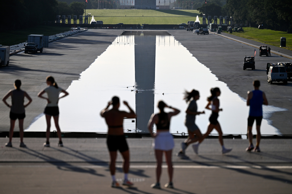 Early morning joggers observer the refilling of the Lincoln Memorial Reflecting Pool, on Friday, June 5, 2026, in Washington. (AP Photo/John McDonnell