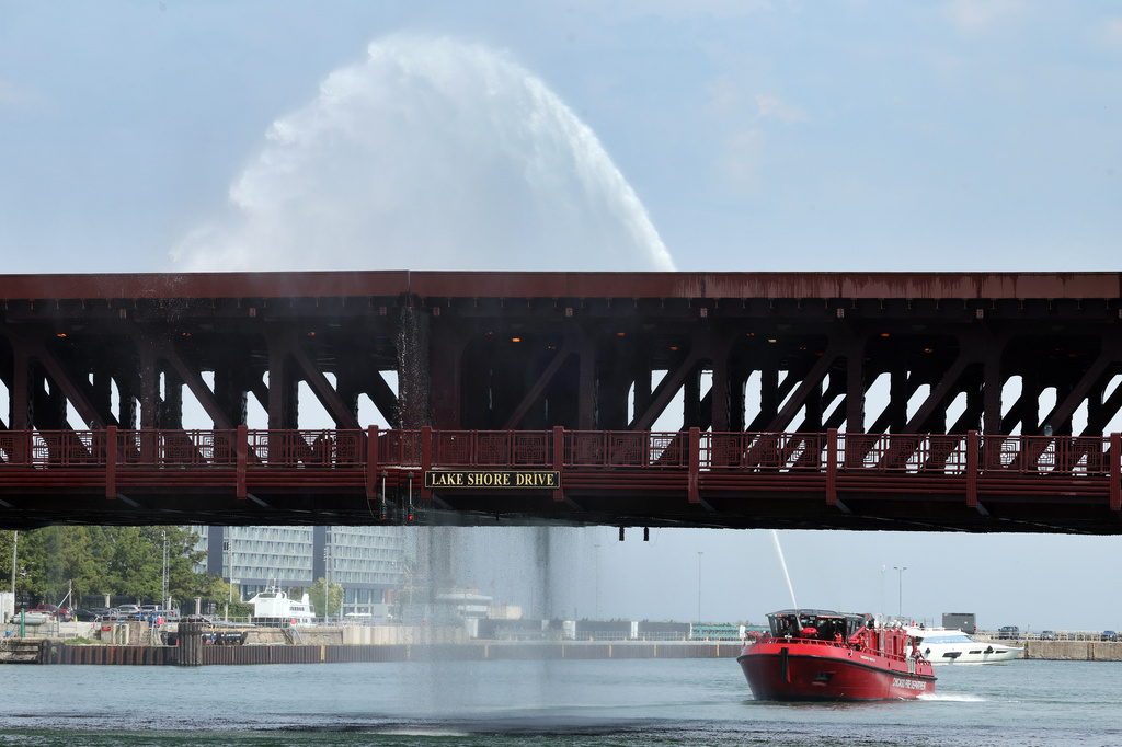Water pumped by a Chicago Fire Department boat flows down onto the DuSable Lake Shore Drive bridge over the Chicago River on Wednesday. Sept. 2, 2026. The double-leaf, double-deck, fixed counterweight bridge became stuck earlier in the day. (Terrence Antonio James/Chicago Tribune via AP)