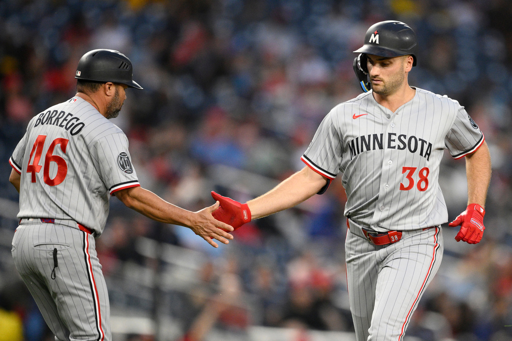 Minnesota Twins' Matt Wallner (38) celebrates his home run with third base coach Ramon Borrego (46) during the fifth inning of a baseball game against the Washington Nationals, Wednesday, May 6, 2026, in Washington. (AP Photo/Nick Wass)