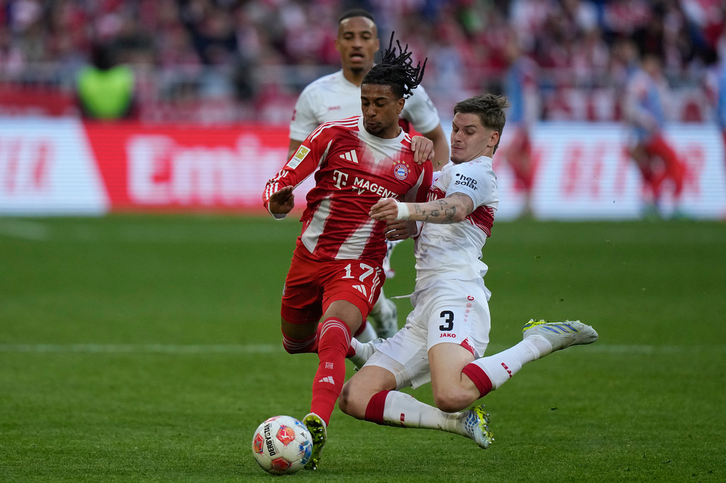 Bayern's Michael Olise, left, and Stuttgart's Ramon Hendriks fight for the ball during a Bundesliga soccer match between Bayern and Stuttgart in Munich, Germany, Sunday, April 19, 2026. (AP Photo/Matthias Schrader)