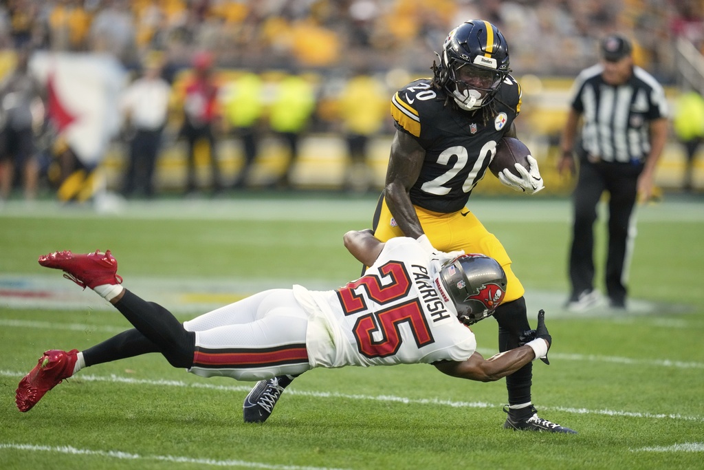 Pittsburgh Steelers running back Kaleb Johnson (20) is tackled by Tampa Bay Buccaneers cornerback Jacob Parrish (25) during the first half of an NFL football preseason game, Saturday, Aug. 16, 2025 in Pittsburgh. (AP Photo/Sue Ogrocki)