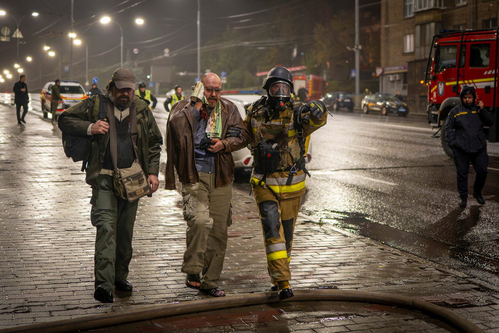 A rescuer helps an injured man after a Russian strike on a residential building in Kyiv, Ukraine, Friday, Oct. 10, 2025. (AP Photo/Dan Bashakov)