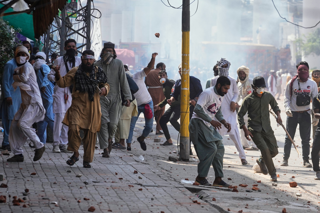 Supporters of Islamist party 'Tehreek-e-Labbaik Pakistan' throw stones toward police during clashes ahead of their pro-Palestinian march toward capital Islamabad, in Lahore, Pakistan, Friday, Oct. 10, 2025. (AP Photo/K.M. Chaudary)