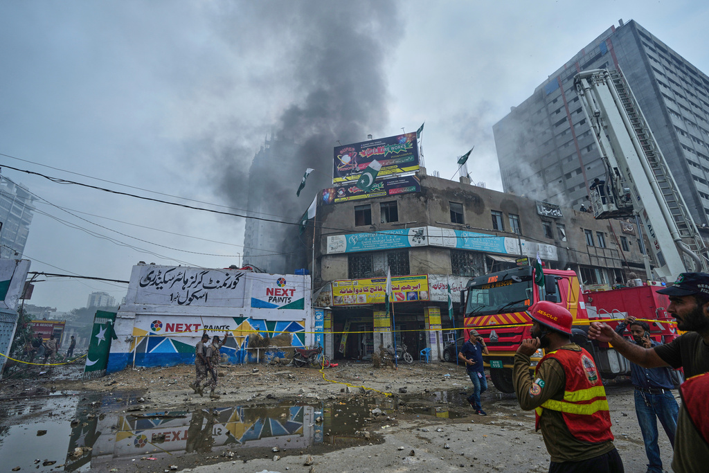 Firefighters try to extinguish a fire following an explosion at a fireworks storage facility, in Karachi, Pakistan, Thursday, Aug. 21, 2025. (AP Photo/Fareed Khan)