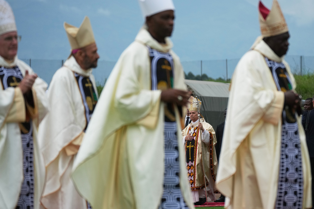 Pope Leo XIV, background, arrives in procession with cardinals and bishops to celebrate a Mass at Bamenda Airport, Cameroon, Thursday, April 16, 2026, on the fourth day of his 11-day pastoral visit to Africa. (AP Photo/Andrew Medichini)