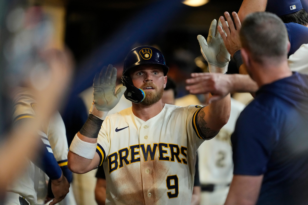 Milwaukee Brewers' Jake Bauers is congratulated in the dugout after hitting a two-run home run during the sixth inning of a baseball game against the Seattle Mariners, Tuesday, Aug. 18, 2026, in Milwaukee. (AP Photo/Aaron Gash)