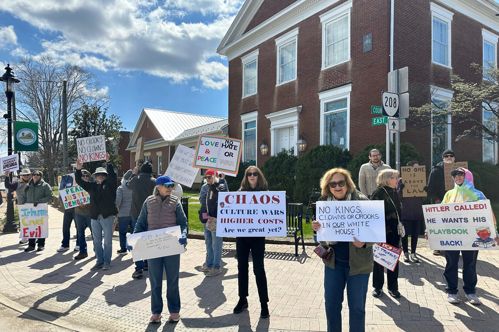 Demonstrators wave signs at drivers during a "No Kings" protest in Louisa County, Va., on Saturday, March 28, 2026. (AP Photo/Olivia Diaz)