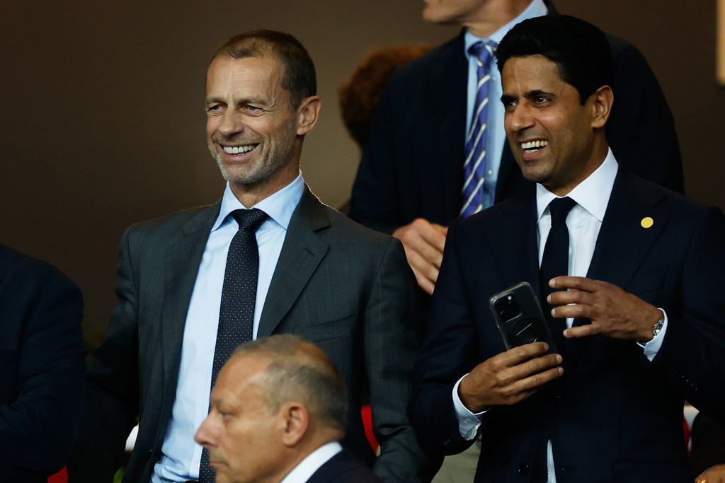 UEFA President Aleksander Ceferin, left, and Paris Saint-Germain Nasser Al-Khelaifi smile prior to the Champions League opening phase soccer match between Barcelona and Paris Saint-Germain at the Lluis Companys Olympic Stadium in Barcelona, Spain, Wednesday, Oct. 1, 2025. (AP Photo/Joan Monfort)