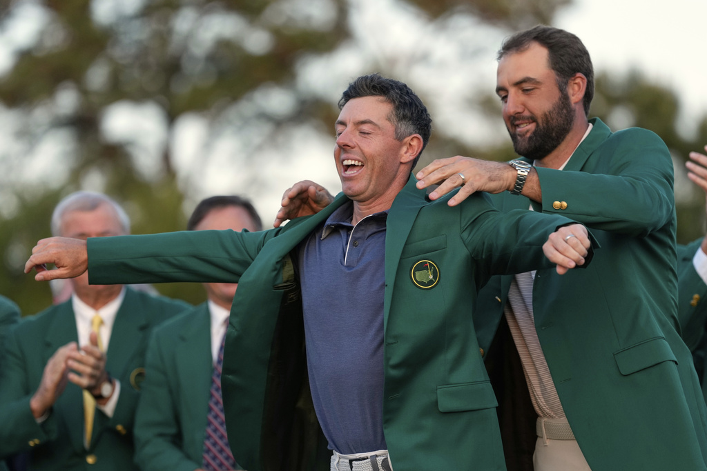 FILE - Scottie Scheffler puts the green Jacket on winner, Rory McIlroy, of Northern Ireland, at the Masters golf tournament, Sunday, April 13, 2025, in Augusta, Ga. (AP Photo/Ashley Landis, File)