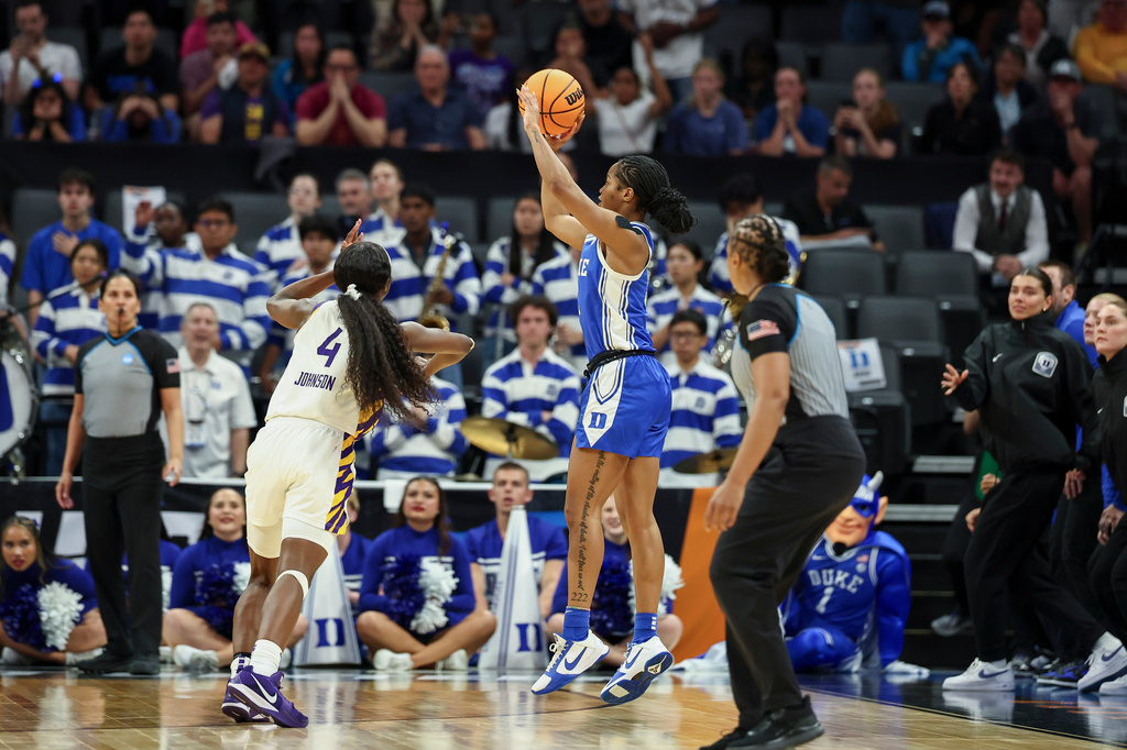 Duke guard Ashlon Jackson, center, makes a 3-pointer over LSU guard Flau'jae Johnson (4) as the clock runs out in the fourth quarter in the Sweet 16 of the NCAA college basketball tournament Friday, March 27, 2026, in Sacramento, Calif. (AP Photo/Sara Nevis)