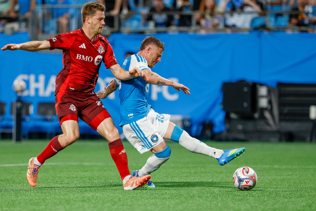 Charlotte FC midfielder Pep Biel, right, shoots against Toronto FC defender Walker Zimmerman, left, during the first half of an MLS soccer match in Charlotte, N.C., Saturday, May 16, 2026. (AP Photo/Nell Redmond)