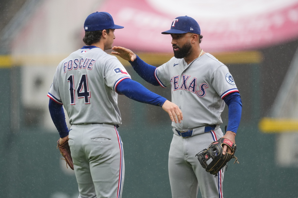 Texas Rangers second baseman Justin Foscue, left, congratulates shortstop Ezequiel Duran after defeating the Colorado Rockies in a baseball game Wednesday, May 20, 2026, in Denver. (AP Photo/David Zalubowski)
