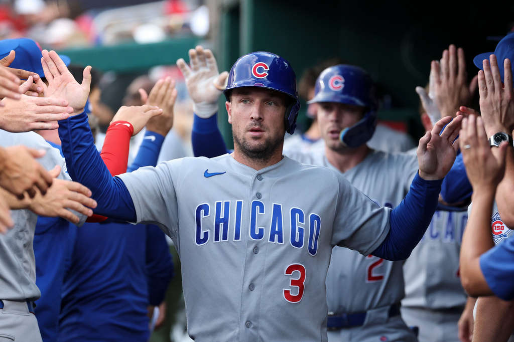 Chicago Cubs' Alex Bregman (3) is greeted in the dugout by teammates after scoring a run on a sacrifice fly hit by Nico Hoerner off of Washington Nationals pitcher Jake Irvin during the second inning of a baseball game in Washington, Tuesday, Aug 11, 2026. (AP Photo/Terrance Williams)