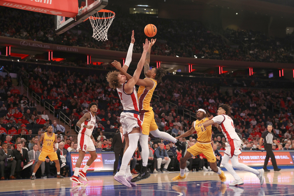 Iona's Lamin Sabally (9) collides with St. John's Ruben Prey (17) while shooting during the first half of an NCAA college basketball game Saturday, Dec. 13, 2025, in New York. (AP Photo/Pamela Smith)