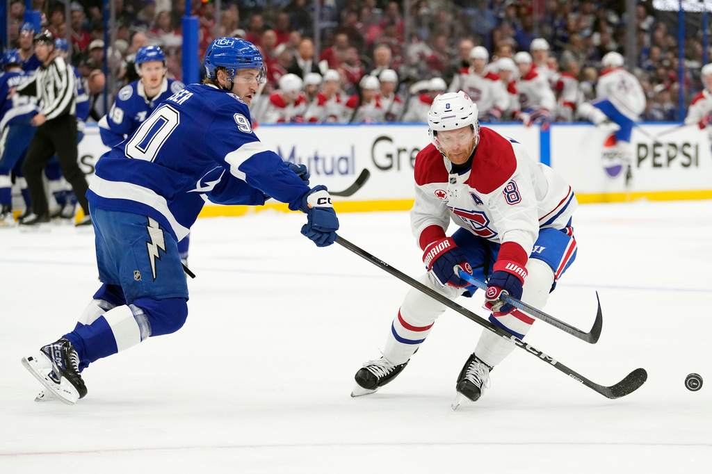Tampa Bay Lightning defenseman J.J. Moser (90) knocks the puck away from Montréal Canadiens defenseman Mike Matheson (8) during the first period in Game 1 of an NHL hockey Stanley Cup first-round playoff series, Sunday, April 19, 2026, in Tampa, Fla. (AP Photo/Chris O'Meara)