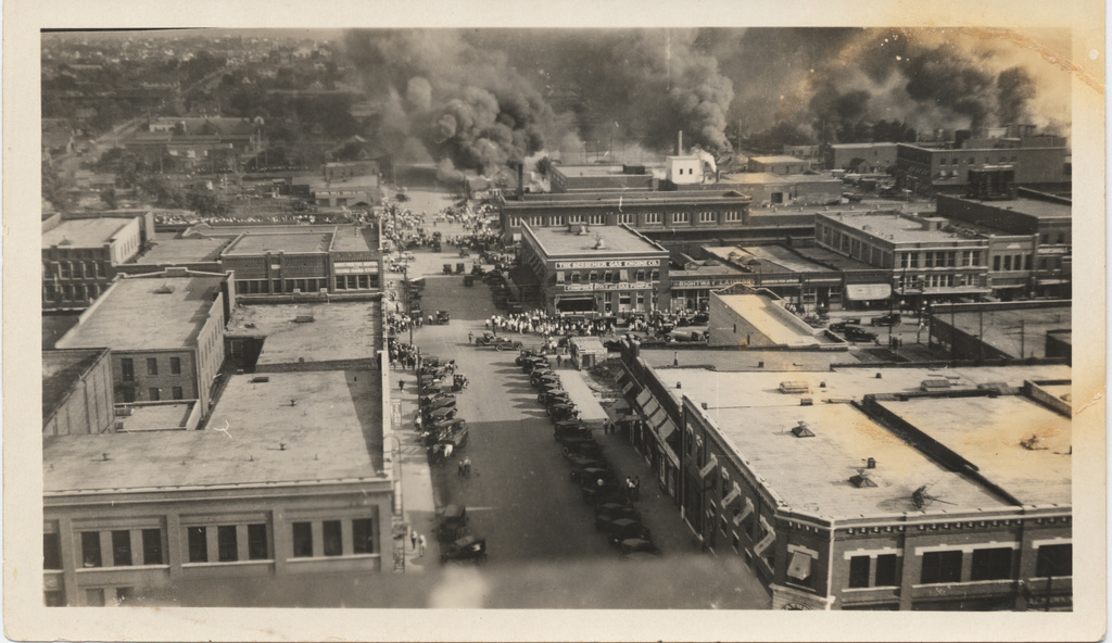 This photo provided by The University of Tulsa and taken from the roof of the Tulsa Hotel shows a crowd gathering to watch the fire in the morning of June 1, 1921, in Tulsa, Okla. (The University of Tulsa McFarlin Library/Department of Special Collections and University Archives via AP)