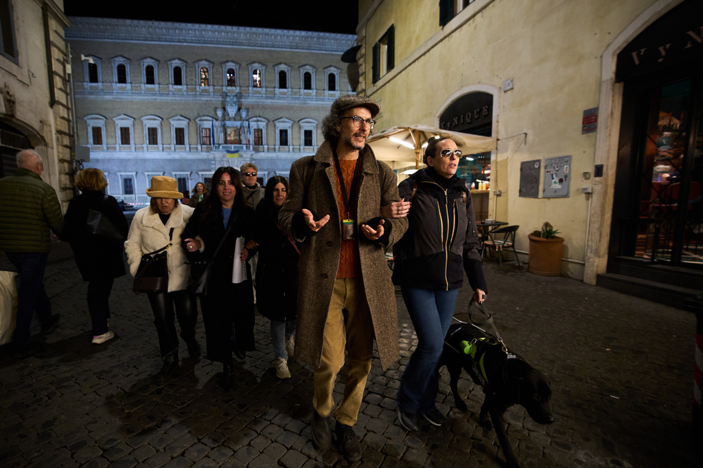 Giorgio Guardi, center, a guide from the Radici Association, walks with participants during one of their inclusive art tours in central Rome, Nov. 29, 2025. (AP Photo/Alessandra Tarantino)
