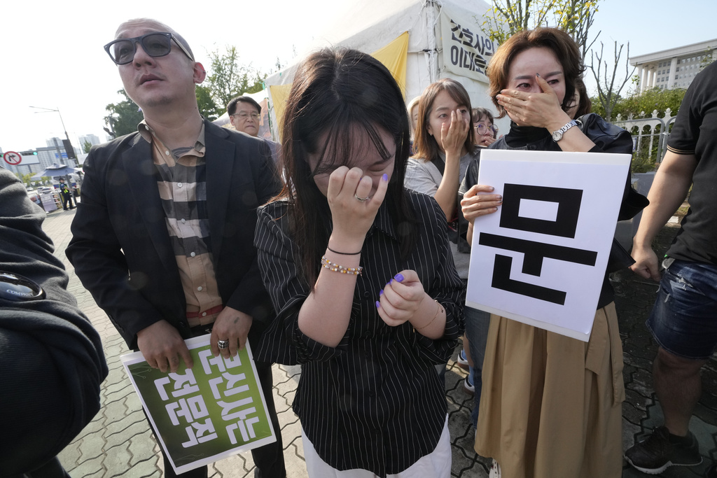 Members of the Korea Tattoo Federation weep during a press conference demanding to the parliament to pass a bill that would allow non-medical personnel to give tattoos outside the National Assembly in Seoul, South Korea, Thursday, Sept. 25, 2025, (AP Photo/Ahn Young-joon)