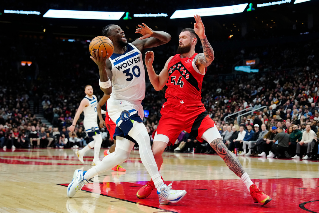 Minnesota Timberwolves' Julius Randle (30) drives at Toronto Raptors' Sandro Mamukelashvili (54) during the first half of an NBA basketball game in Toronto, Wednesday, Feb. 4, 2026. (Frank Gunn/The Canadian Press via AP)
