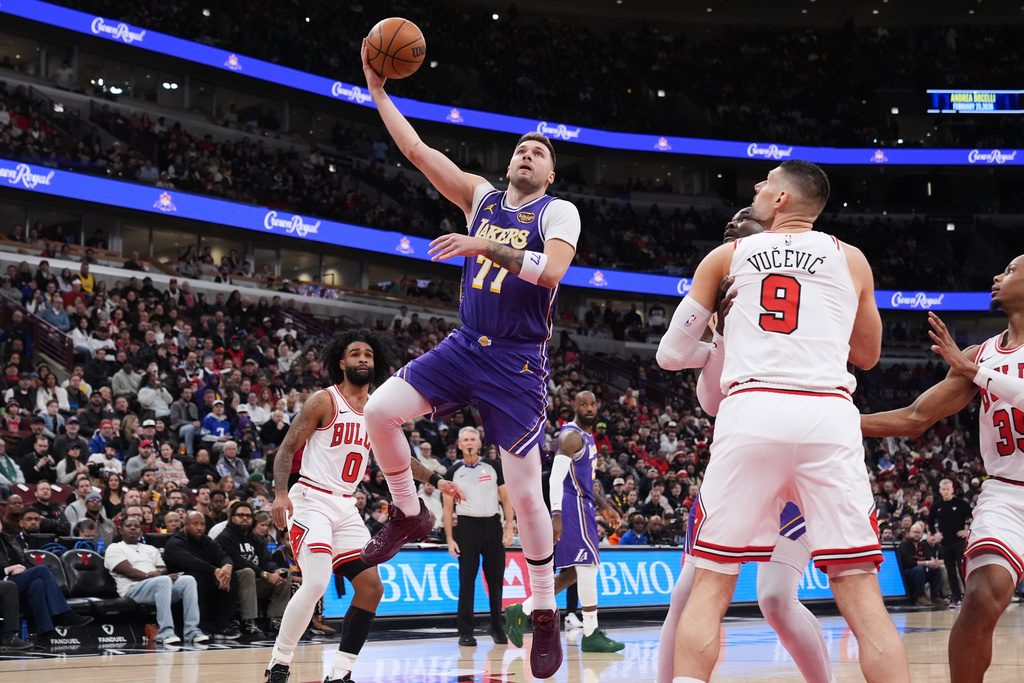 Los Angeles Lakers guard Luka Doncic (77) drives to the basket as Chicago Bulls center Nikola Vucevic (9) watches during the first half of an NBA basketball game in Chicago, Monday, Jan. 26, 2026. (AP Photo/Nam Y. Huh)