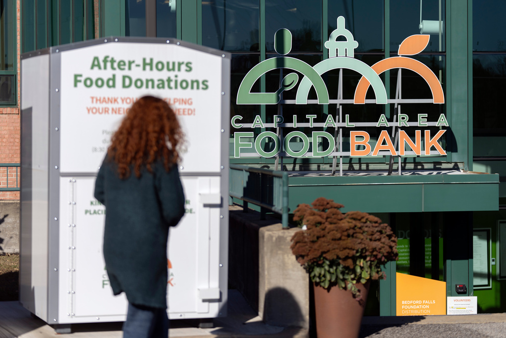 A person walks toward the entrance of the Capital Area Food Bank, Thursday, Nov. 6, 2025, in Washington. (AP Photo/Mark Schiefelbein)