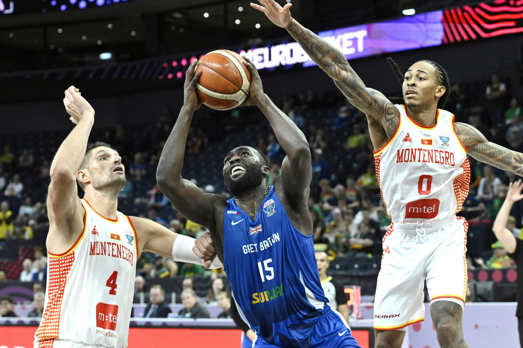 Montenegro's Nikola Vucevic, left, and Kyle Allman Jr., right, challenge for the ball with Britain's Akwasi Yeboah, center, during the Eurobasket, European Basketball Championship, group B match between Montenegro and Great Britain in Tampere, Finland, Wednesday, Sept. 3, 2025. (Heikki Saukkomaa/Lehtikuva via AP)