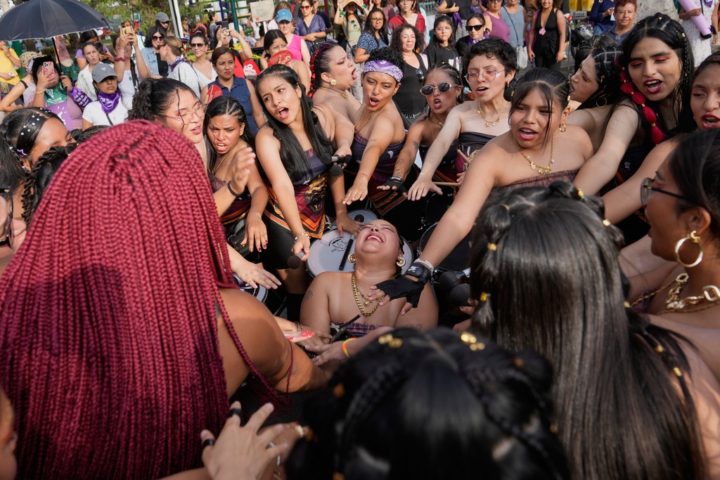 Women perform a good luck ceremony before a march marking International Women's Day, in Lima, Peru, Saturday, March 7, 2026. (AP Photo/Martin Mejia)