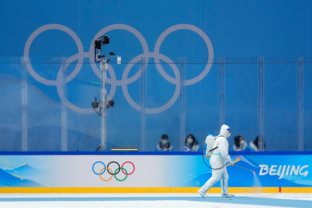FILE - A worker wearing a protective suit disinfects the arena after the women's gold medal hockey game between Canada and the United States at the 2022 Winter Olympics, Feb. 17, 2022, in Beijing. (AP Photo/Petr David Josek, File)